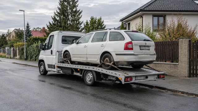 Bílý odtahový vůz s upevněným vozidlem Škoda na hliníkové plošině