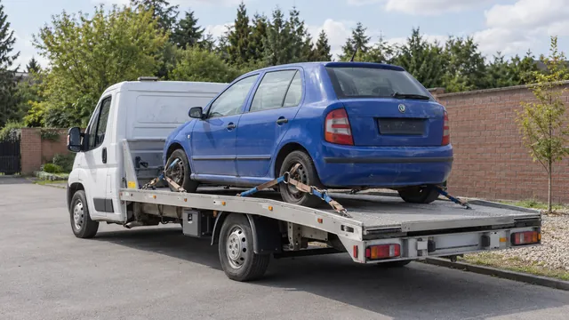 Bílý odtahový vůz s upevněným vozidlem Škoda na hliníkové plošině