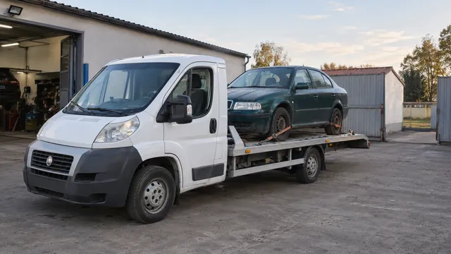Bílý odtahový vůz s upevněným vozidlem Škoda na hliníkové plošině
